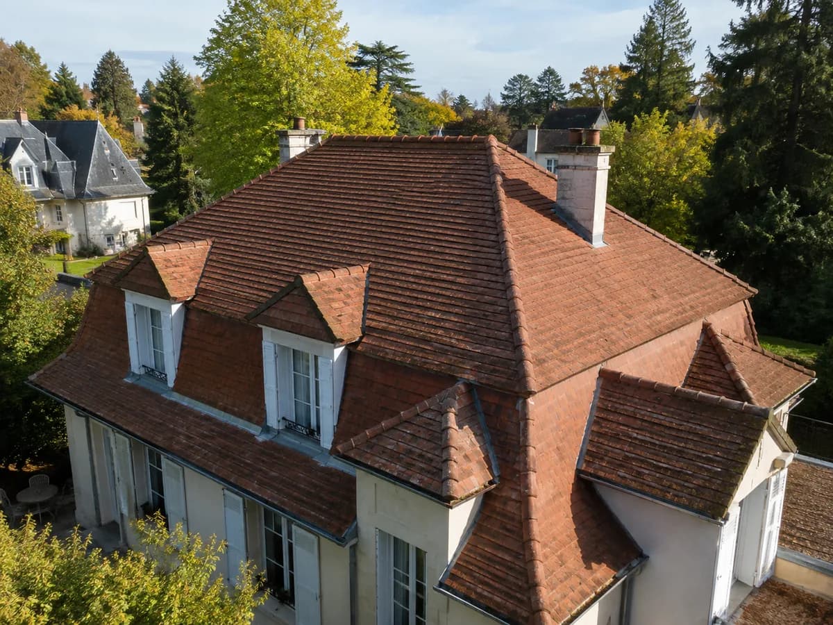 Toiture de villa ancienne en tuiles plates, lucarnes et souches de cheminée — les points à contrôler avant l'automne